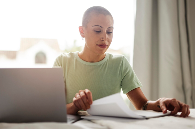 Young adult reading healthcare information at home, representing Private health insurance and support during cancer treatment planning.