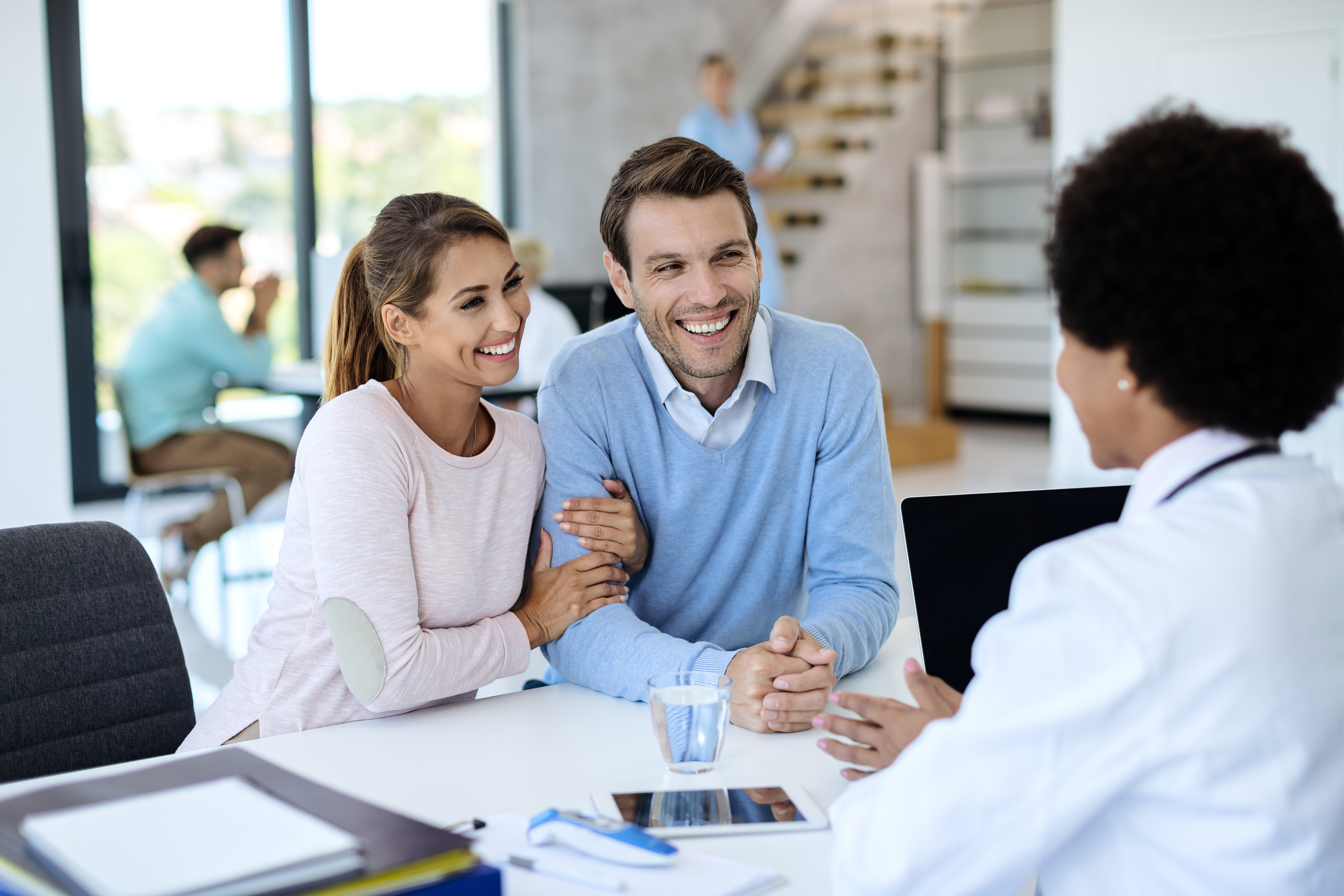 Couple discussing full medical underwriting and health insurance options with a healthcare professional.